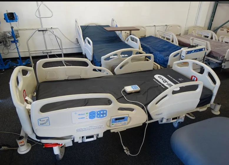 Hill Rom 11170 Care Assist hospital bed with foam mattress, featuring adjustable side rails and control panel for patient comfort.