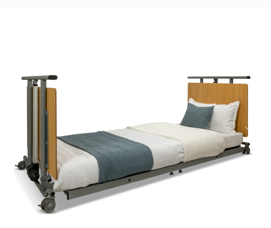 A hospital-style adjustable bed frame with a light wood headboard and footboard, dark gray metal frame and side rails on wheels, shown with white bedding and a blue-gray throw blanket on a white background.
