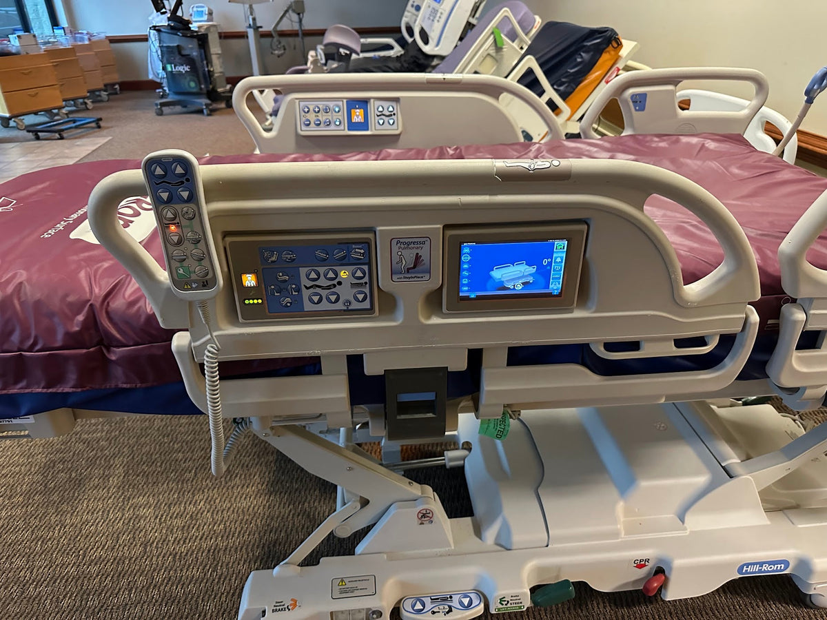 Hospital bed with air mattress, Hill Rom P7500 Progressa Bed without percussion feature, shown with adjustable side rails and control panel.