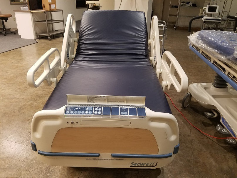 Stryker Secure 2 Model 3002 hospital bed with foam mattress, featuring adjustable side rails and ergonomic design for patient comfort